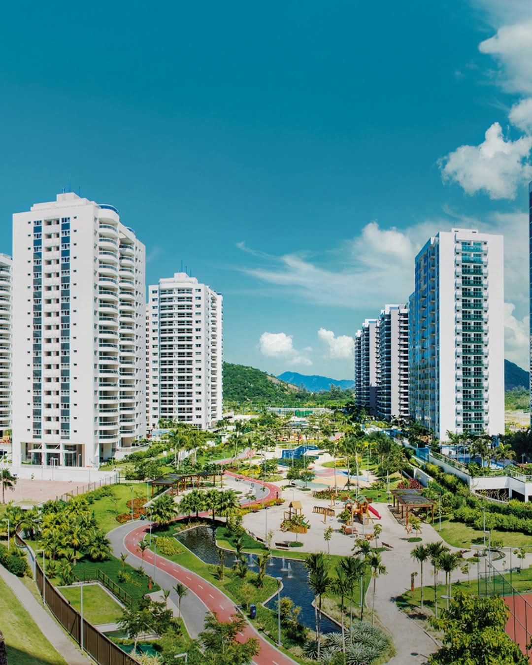 condomínio de edifícios residenciais altos brancos vistos de cima, com parque arborizado, pista vermelha de ca