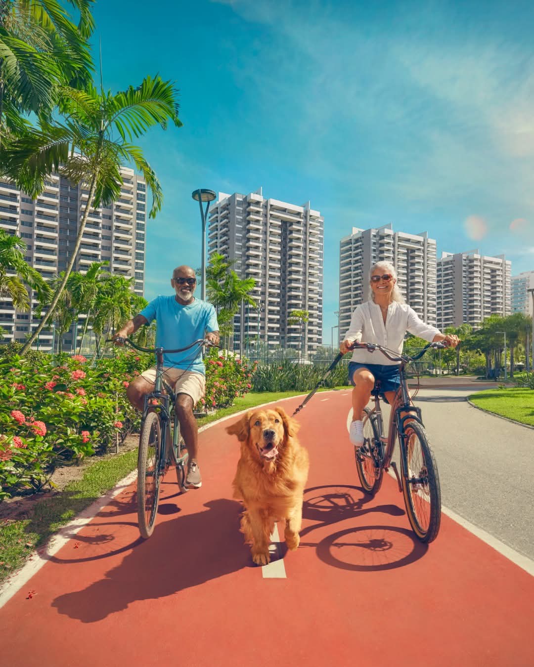 casal de idosos de bicicleta com golden retriever na ciclovia do condomínio