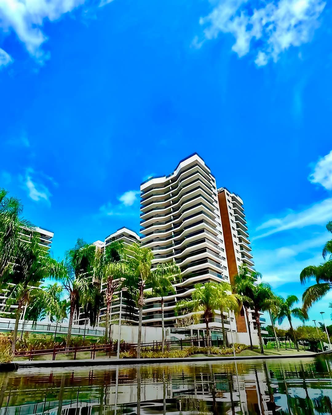 edifício alto branco com vidros azuis na entrada do ORO by Ornare